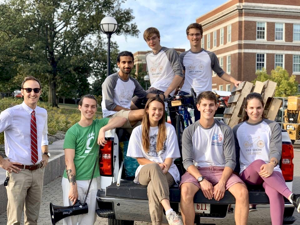 UC students sit on back of pickup truck on main campus.