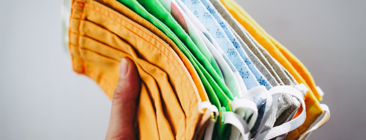 hand holds stack of fabric face masks