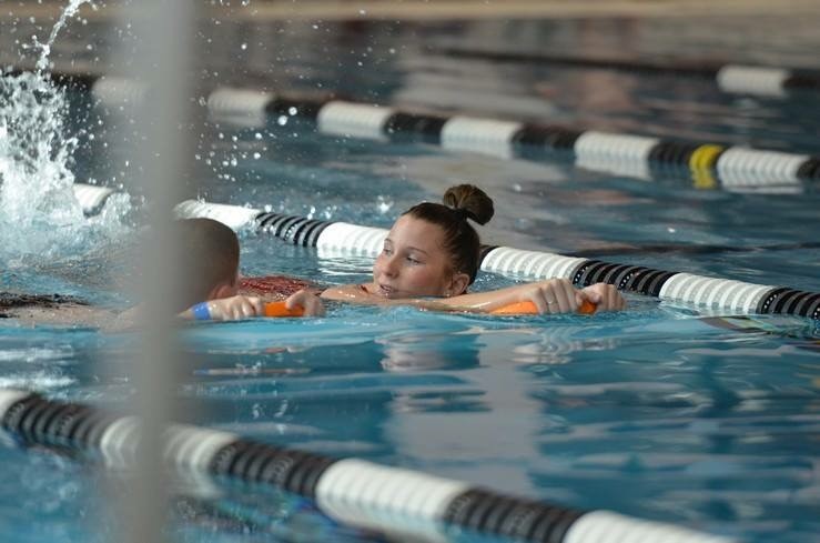 Maria Novak coaches a swimmer in a lap pool.