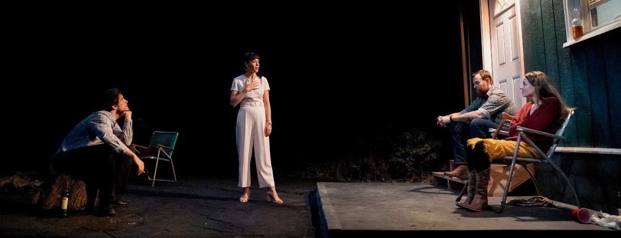 Actors on stage on the set of an outside porch 