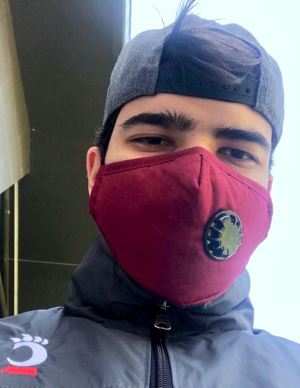 UC's Komronbek Rakhimov wears a PPE face mask and head cover.