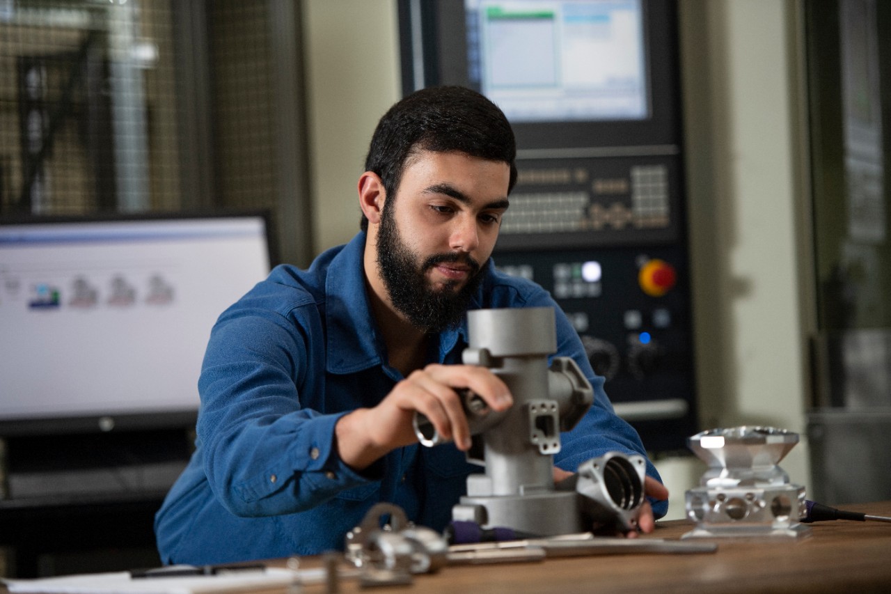 Student at co-op working with a piece of machinery 