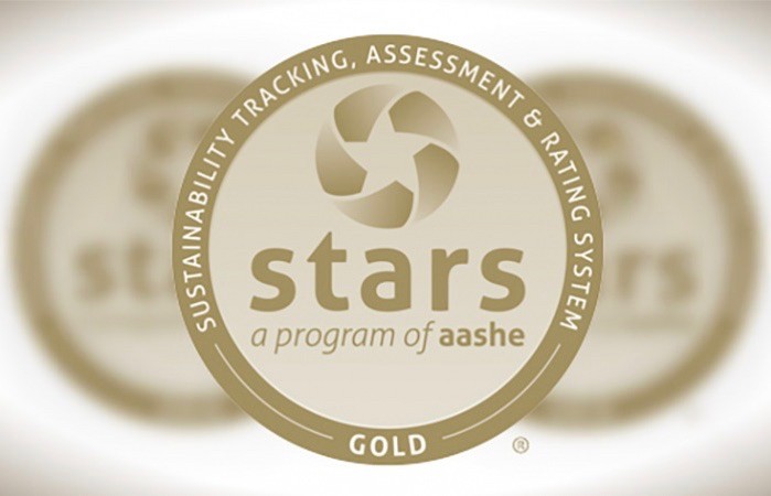 Gold, round symbol with text around perimeter saying Sustainability Tracking, Assessment & Rating System Gold, and STARS a program of AASHE across the center.