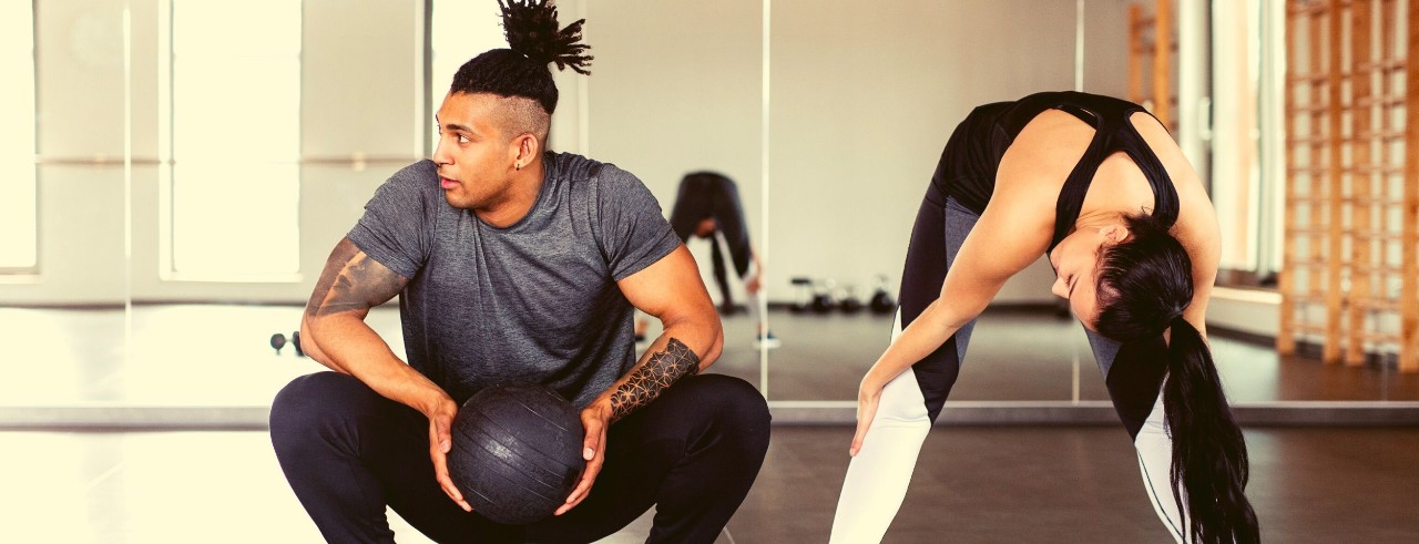 Two people in a gym working out