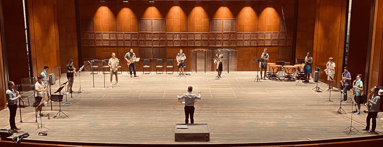 A saxophone ensemble rehearses on stage.
