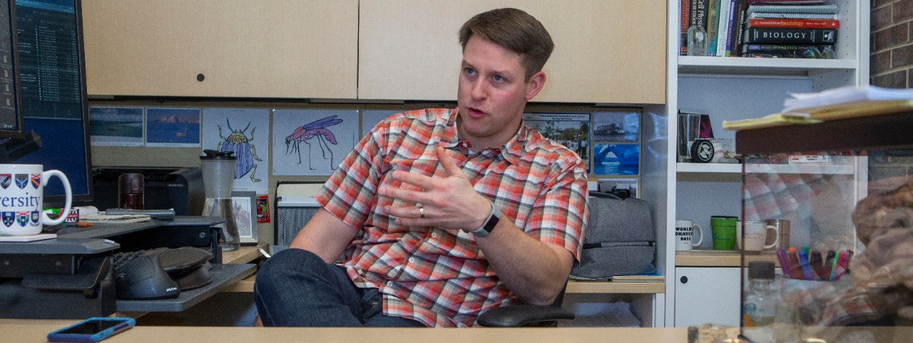 UC biologist Joshua Benoit sits at his desk in his office.