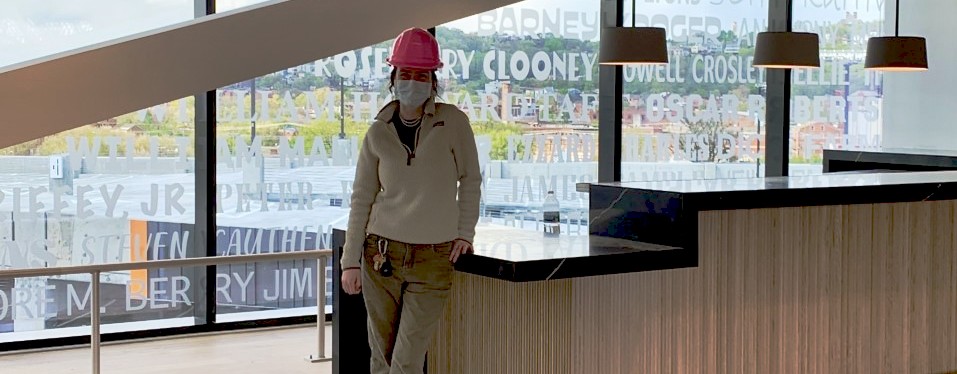UC DAAP student Emily Baxter stands inside a Cincinnati's FC Stadium clubhouse wearing a PPE mask