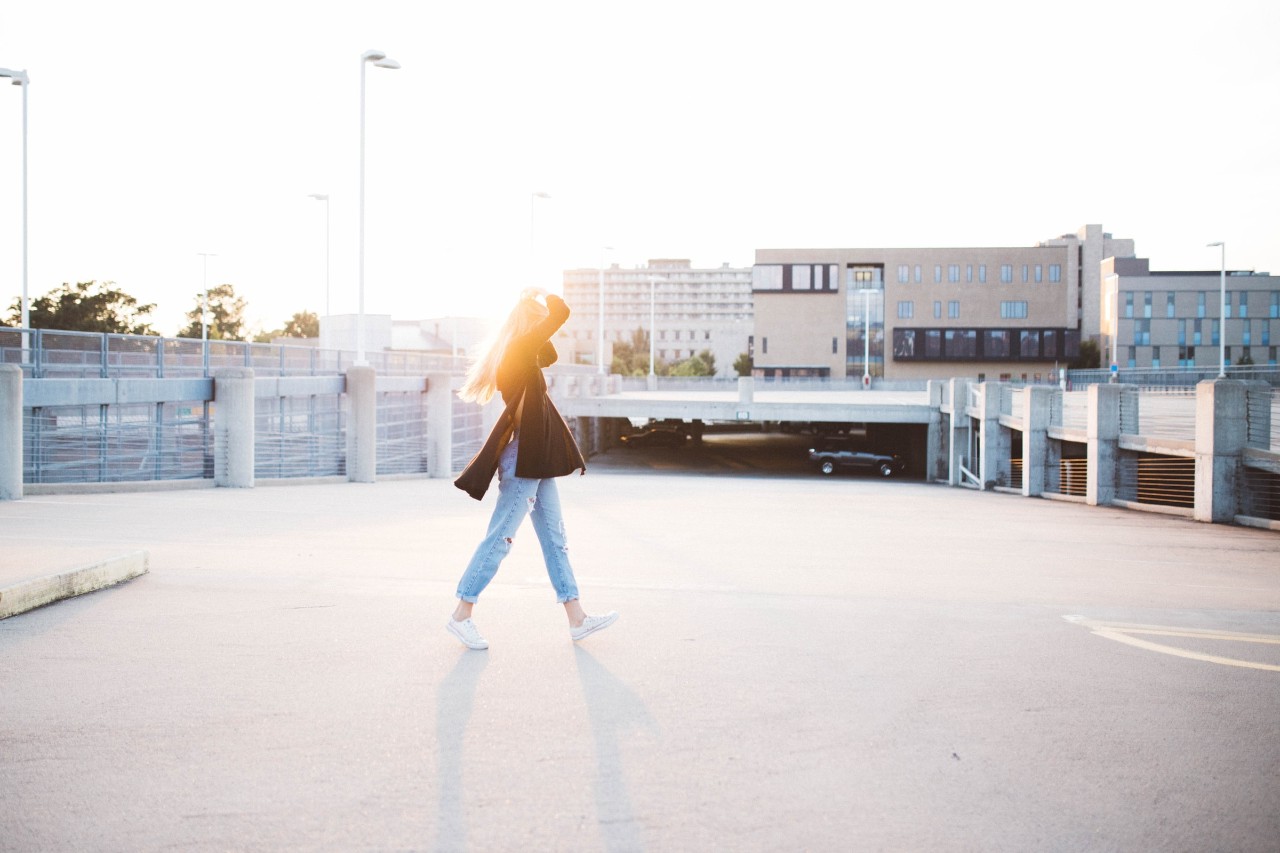 woman walking in the city with sun shining