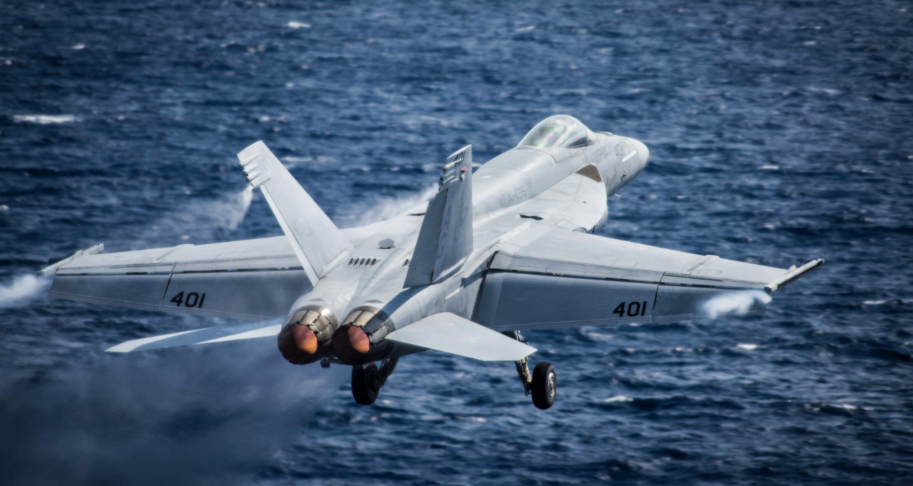Fighter planes fly in tandem over the ocean