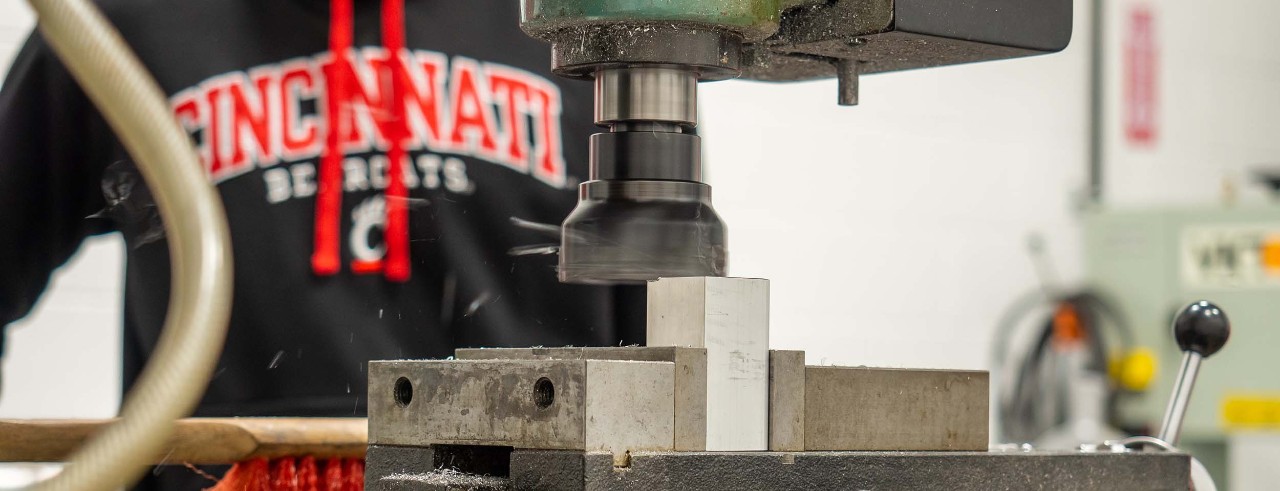 A student uses manufacturing engineering equipment.