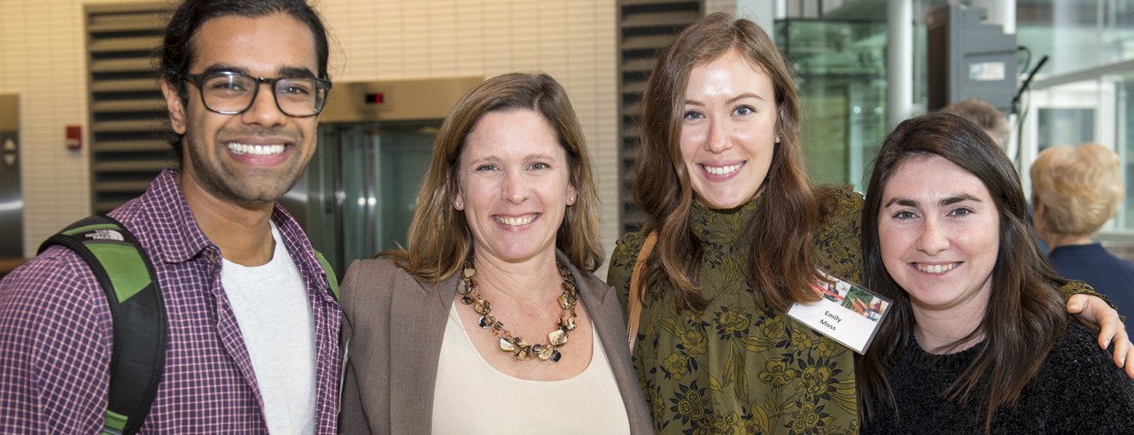 one man and three women, smiling