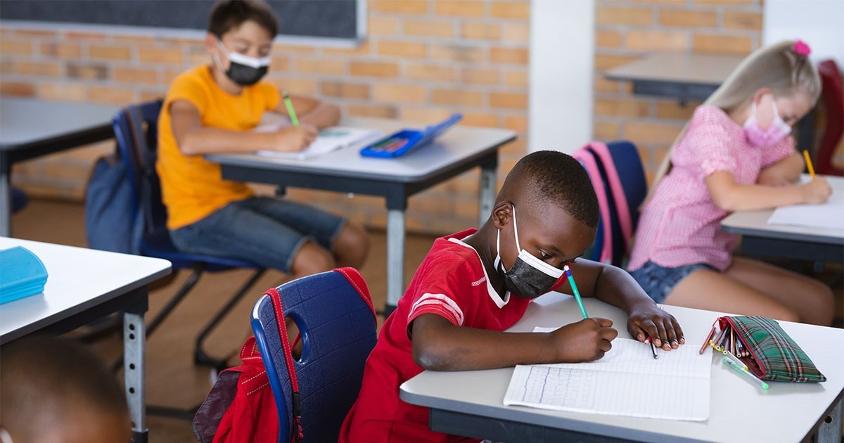 school children sitting at desks doing work