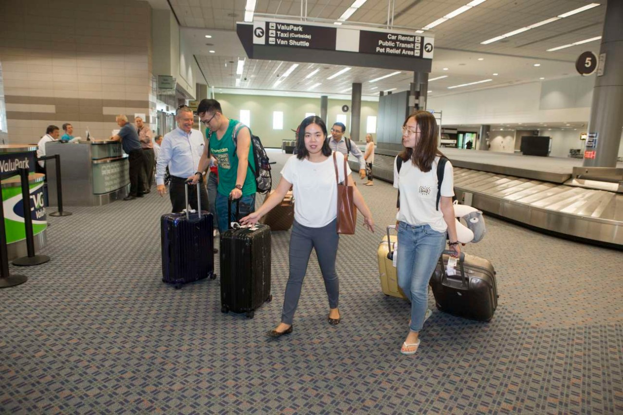 UC students gather their luggage after arriving at Cincinnati-Northern Kentucky International Airport.