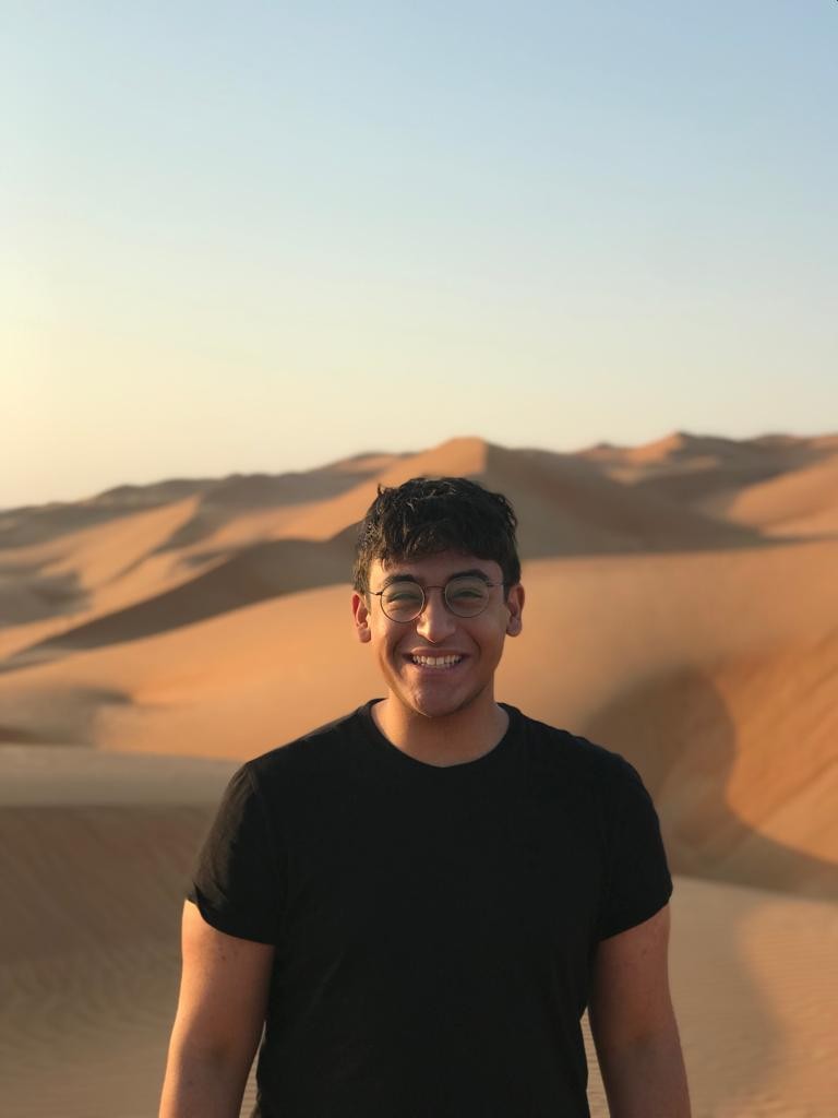 Adam Elzarka stands in a desert during his Boren award in Oman.