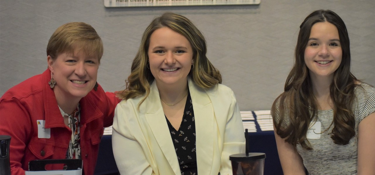 three people seated behind a table