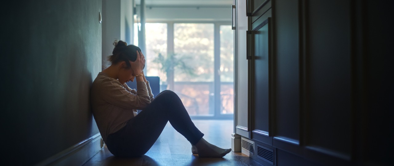 Sad young woman sitting on floor