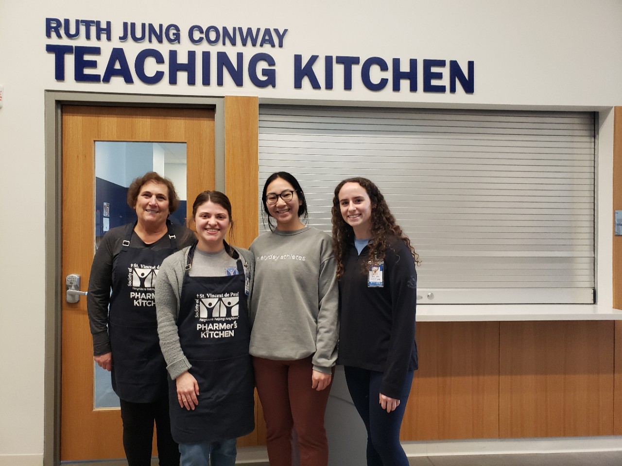 Volunteer Robin Ceddia joins UC students Emily  Wieczorkowski, Monica Chea and Kenzie Pelfrey for a potrait at the Pharmer's Kichten.
