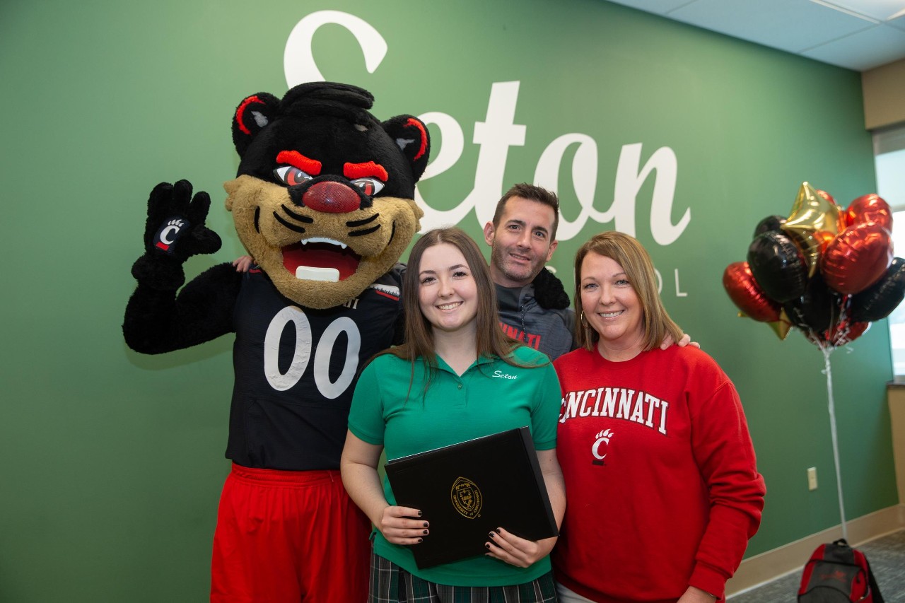Anna Horgan and parents post with Bearcat mascot