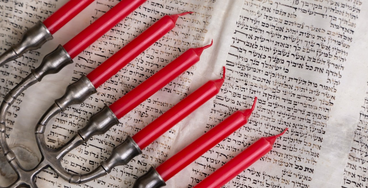 red candles in a menorah on a text book