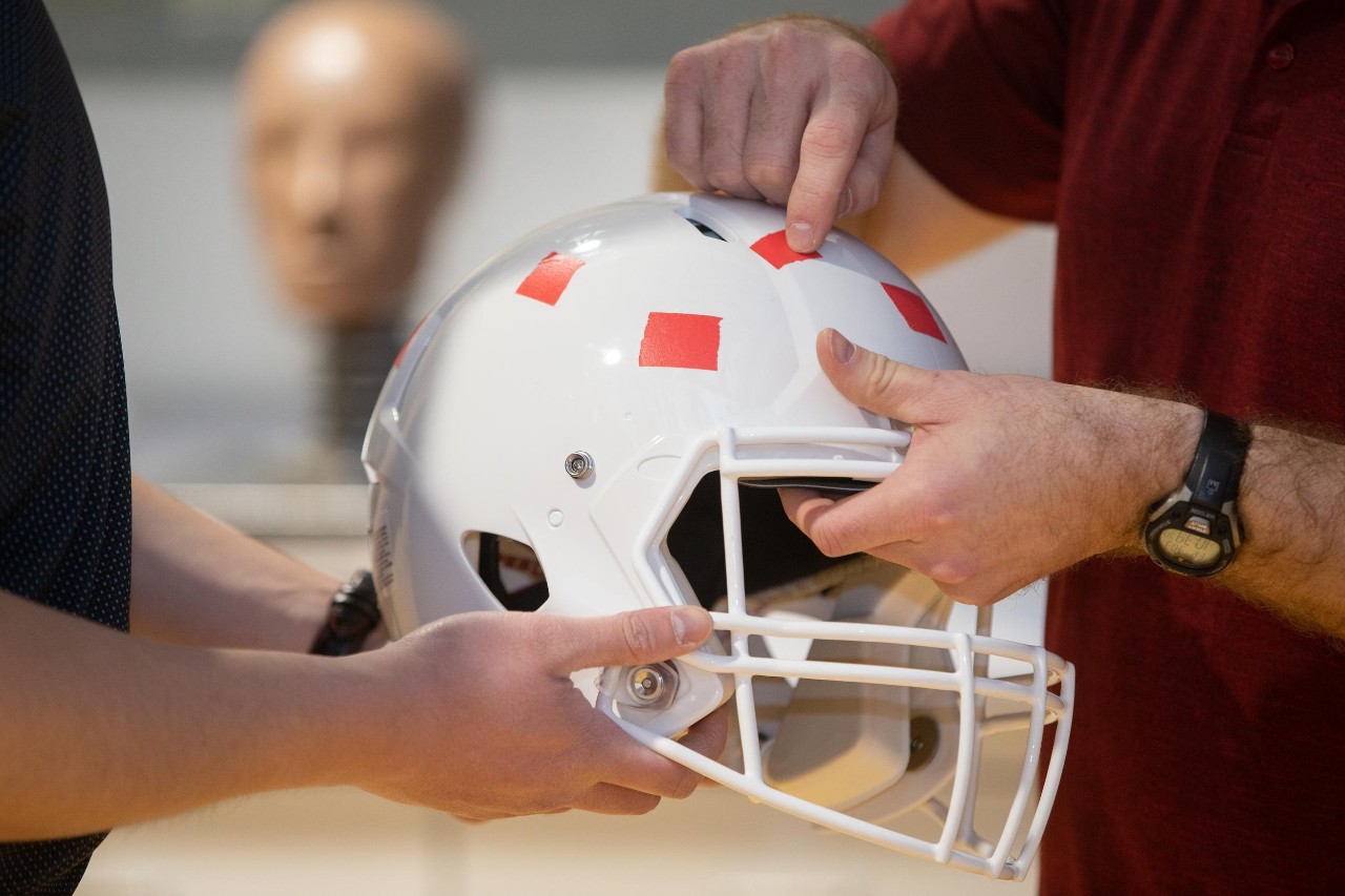 Led by Dr. Eric Nauman, a professor of biomedical engineering in UC’s College of Engineering and Applied Science, University of Cincinnati engineers put popular football helmets made by leading brands through impact testing and found that no single design demonstrated superior reduction of potential concussion incidence or consistent energy absorption at every part of the helmet. Research assistants: Sean Bucherl (ball cap), Christopher Boles (UC sweatshirt), and Shengming Hu (UC polo).