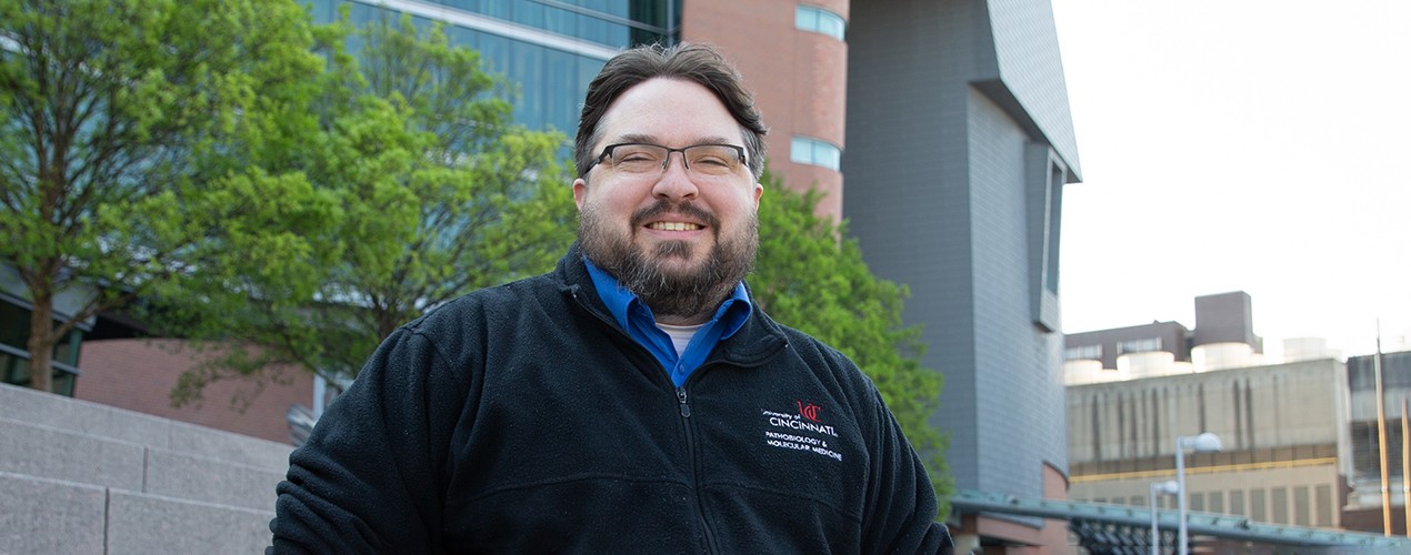 a researcher stands outside the UC College of Medicine