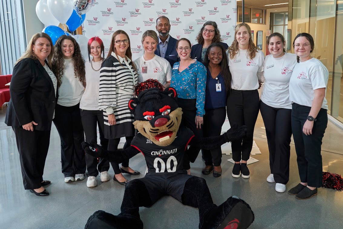 Kroger team poses with the Bearcat and student team at the ribbon cutting