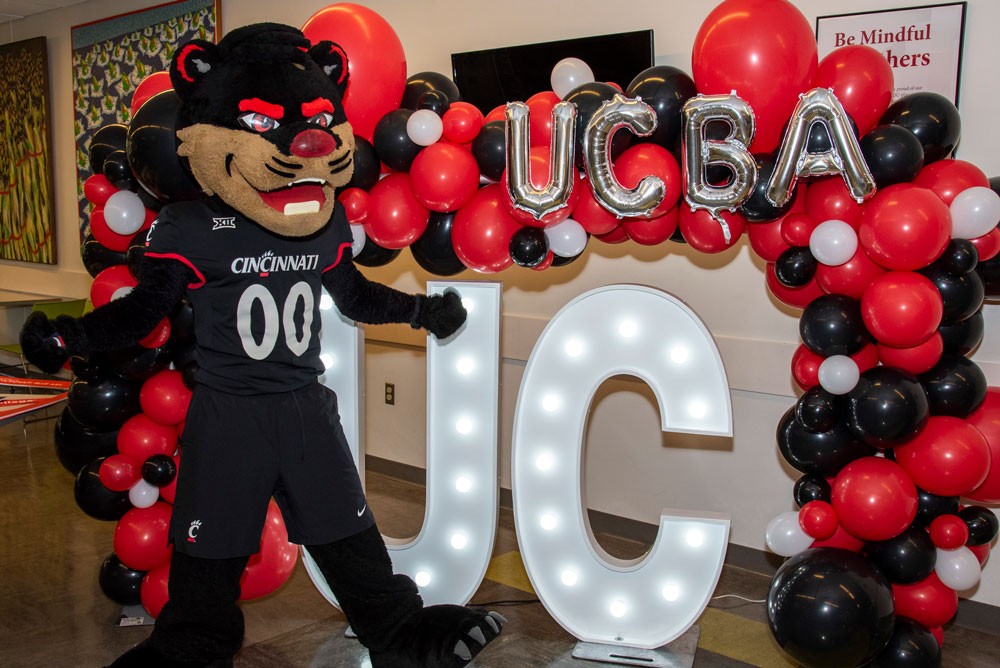 Bearcat mascot in front of UC Blue Ash College balloons