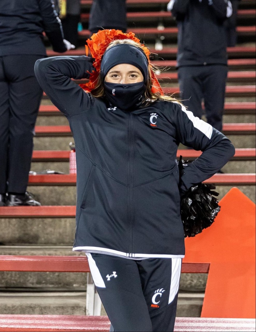 Greer cheering at a football game in a mask
