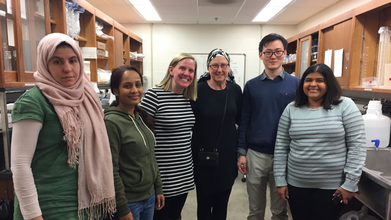 Samar Alanazi and colleagues stand and smile in a laboratory