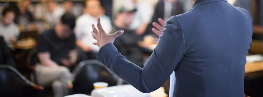 An entrepreneur delivers their business pitch to a room of investors.