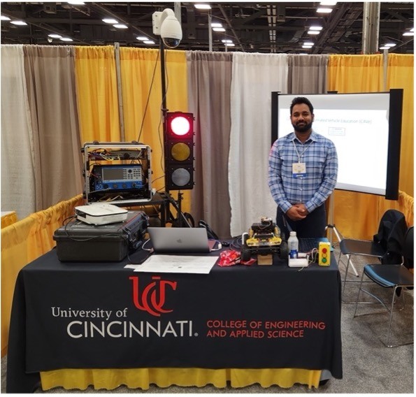 Sai Bonthu stands next to a display of his project 