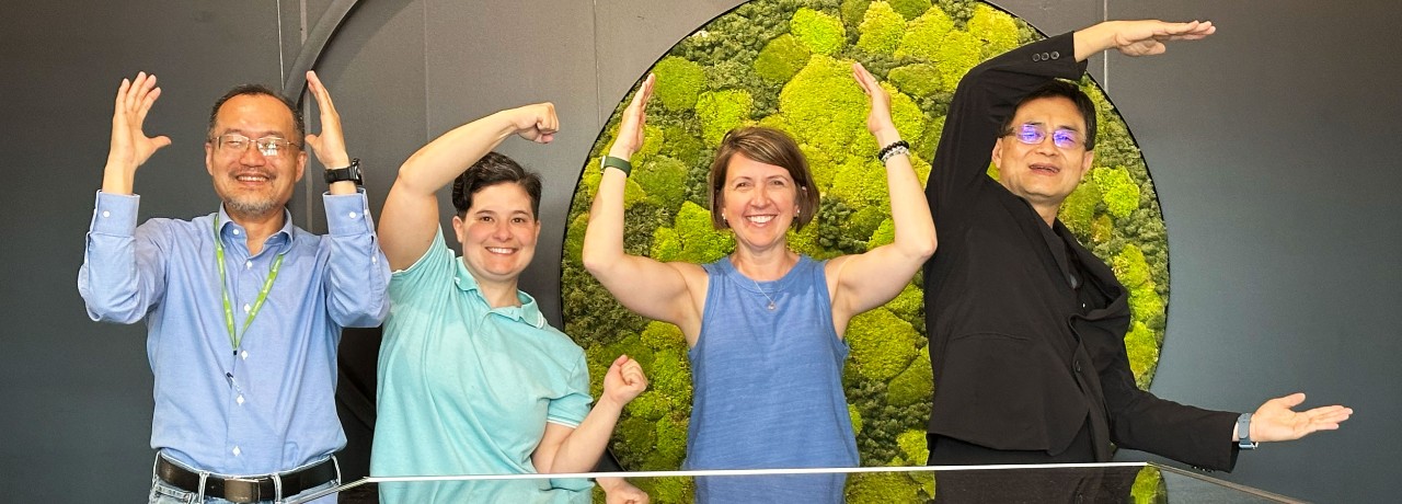 Professors Ibrahim-Taney and Roemer with alumni at the Taiwan Design Research Institute make the UC sign.