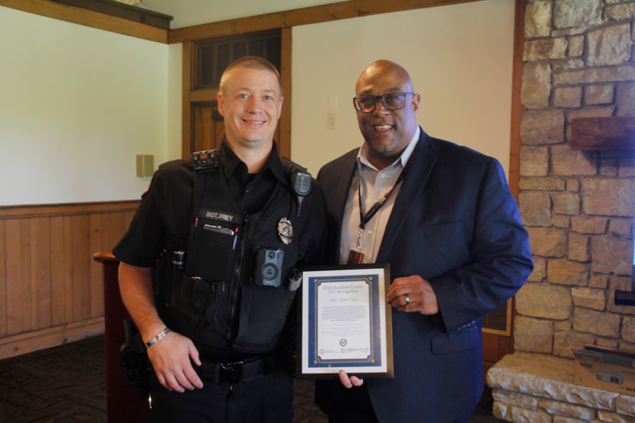 Sgt. Eric Frey, left, and UC Chief of Police and Director of Public Safety Eliot Isaac pose holding Sgt. Frey's honorable mention certificate at the CIT Award breakfast.