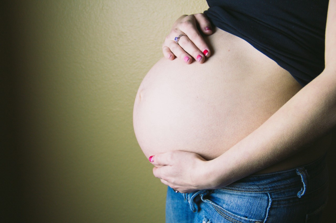 A pregnant woman holds her belly