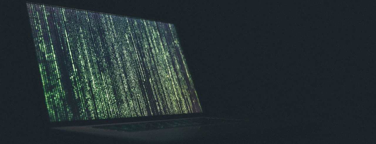 Computer code on a laptop screen in a dark room.