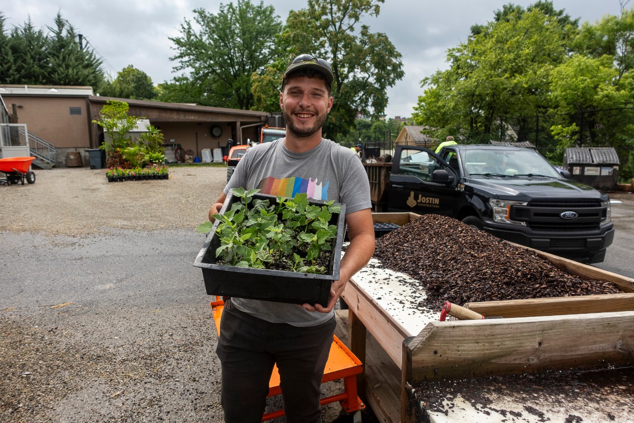 Jack Schaefer smiling with plants as he works as the head arborist at the Cincinnati Zoo & Botanical Garden.