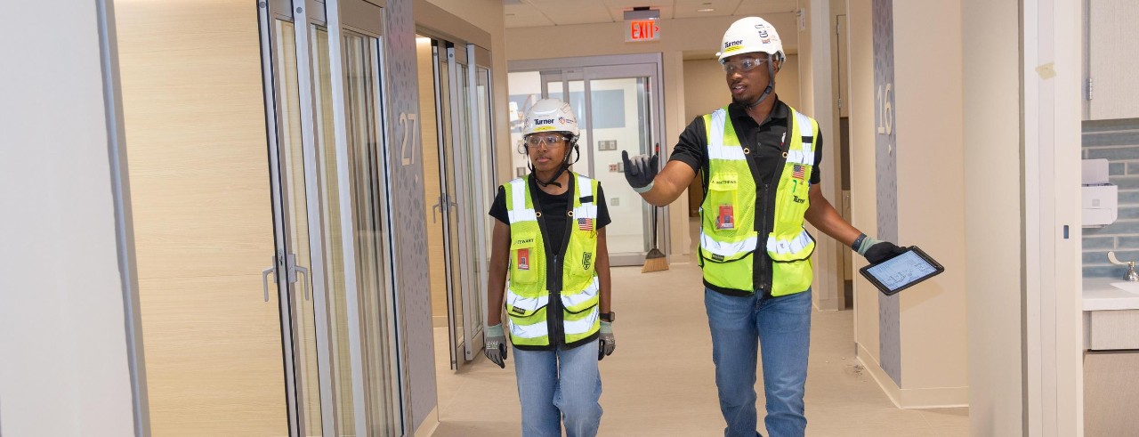UC student Andrew Matthews walks with colleague on a Turner construction site