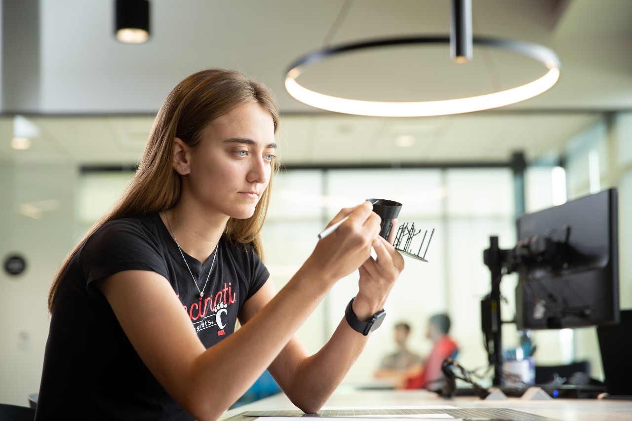 Young women student on co-op inspecting a model