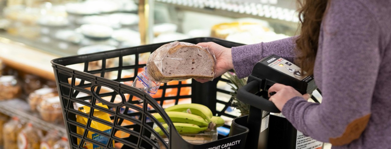 A woman shops for groceries with a motorized shopping cart.
