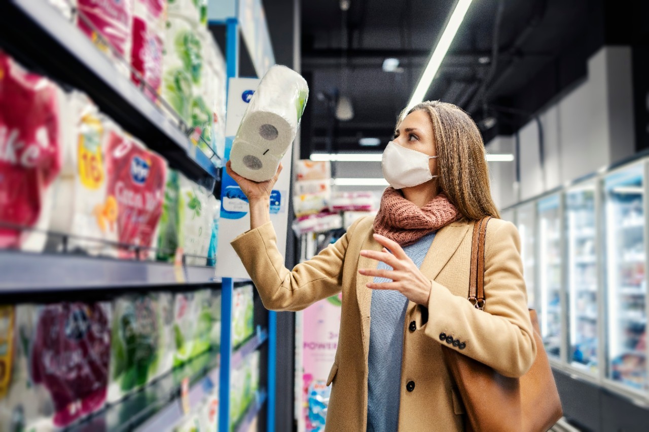Woman shops in a store while wearing a face mask.