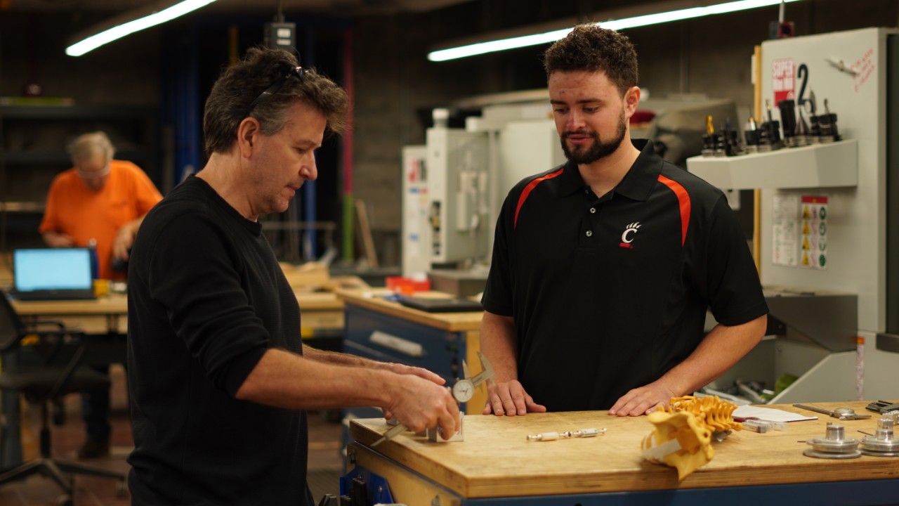 Andy Schiffer and Matthew Karp look at the Vertetrain device. 