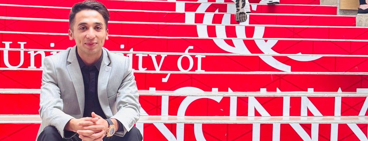 Lindner MBA student Ahmad Bilal Niazi sits on the atrium steps inside Lindner Hall