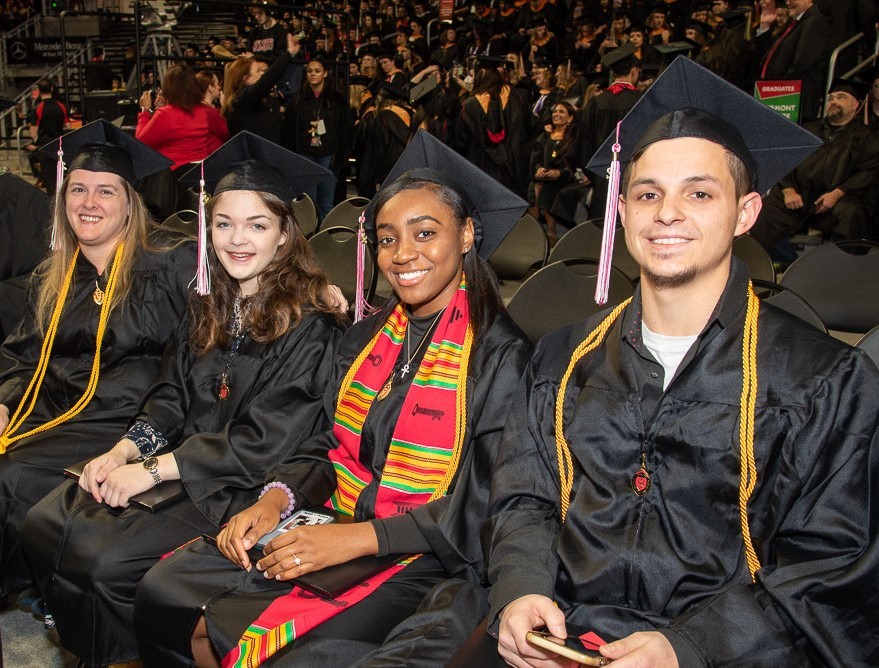 students in hats and gowns at commencement ceremony