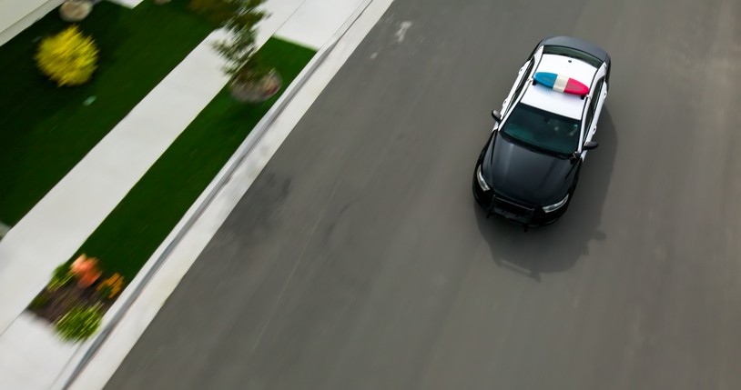 An overhead shot of a police car driving on a residential street