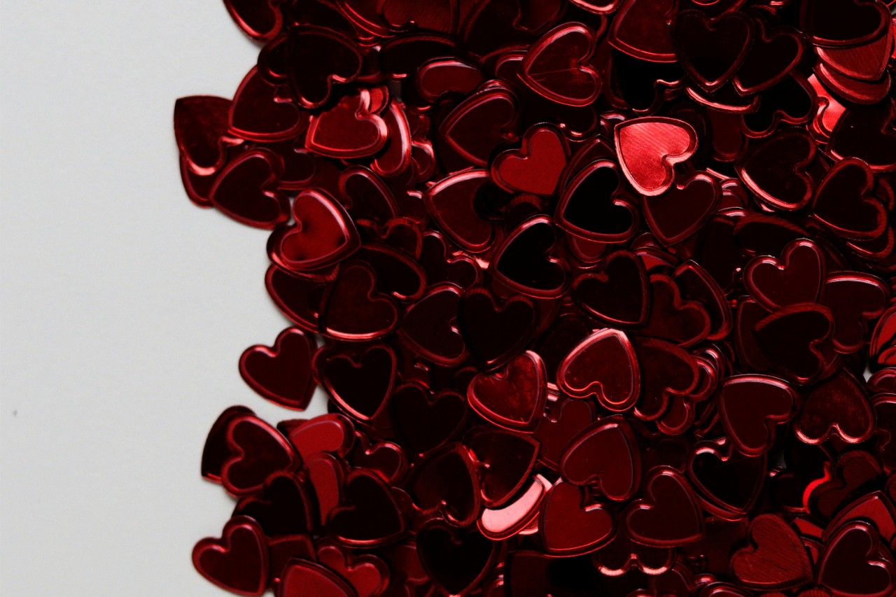 Red shiny hearts on table