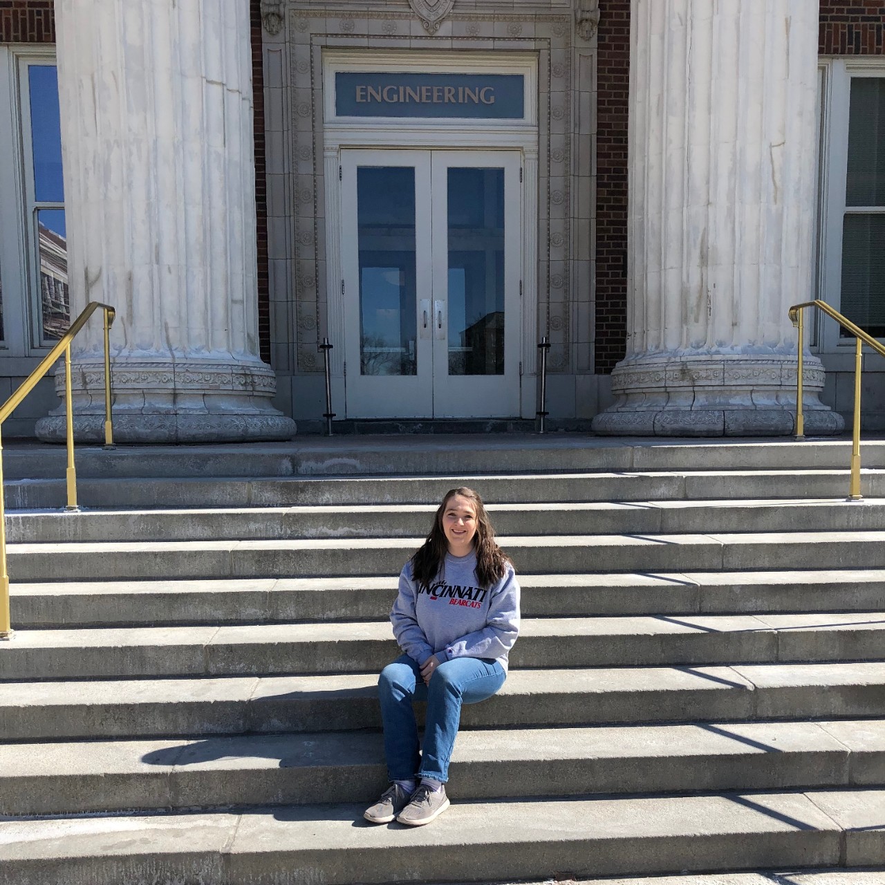 Kara Stall sits on the steps of the University of Cincinnati's Baldwin Hall