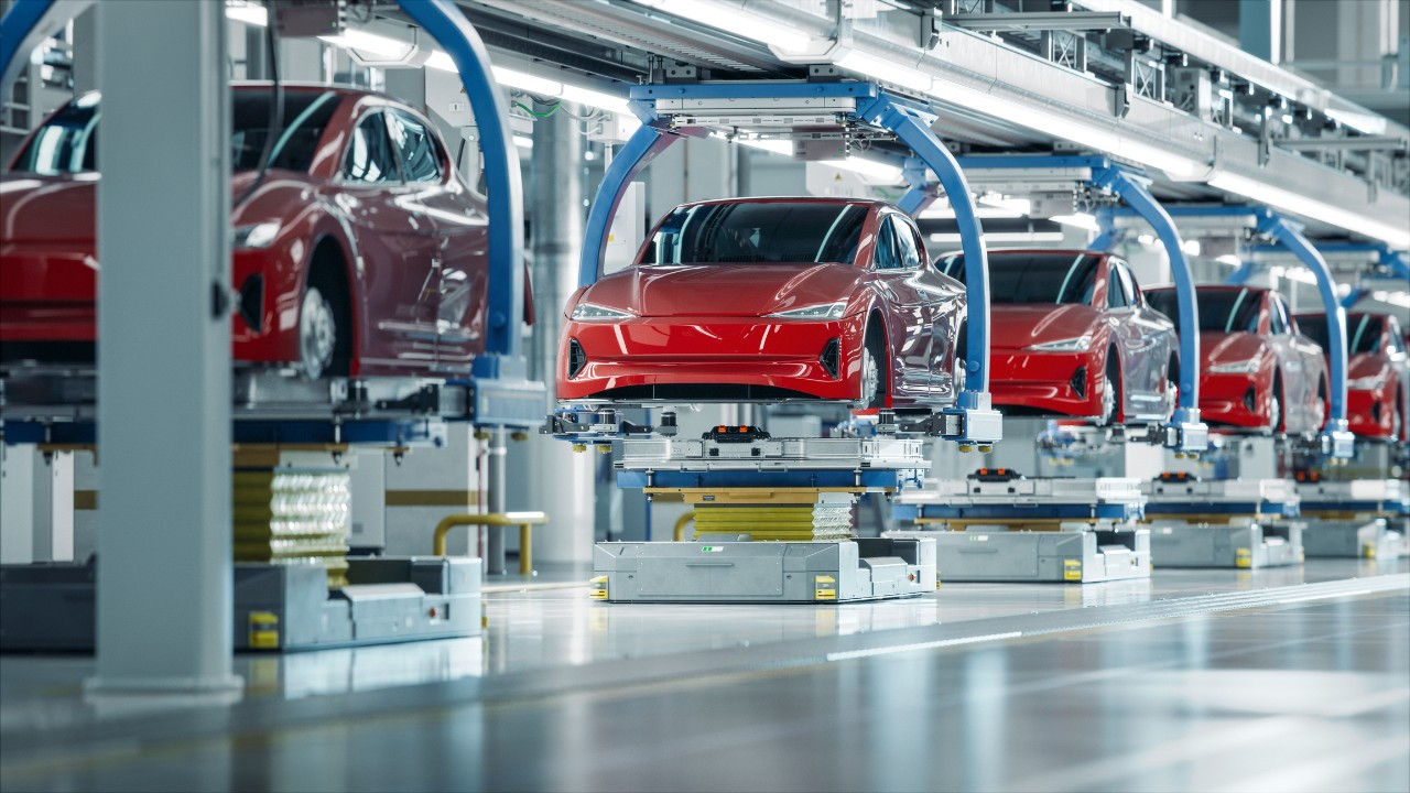 scene in automative plant with cars moving on an assembly line
