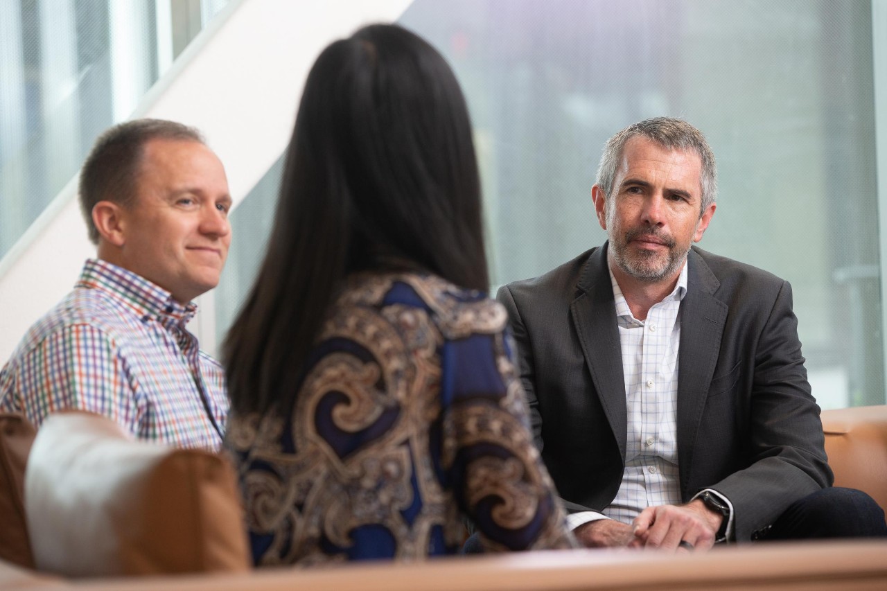 Three professionals in an office setting displaying what to wear to a job interview
