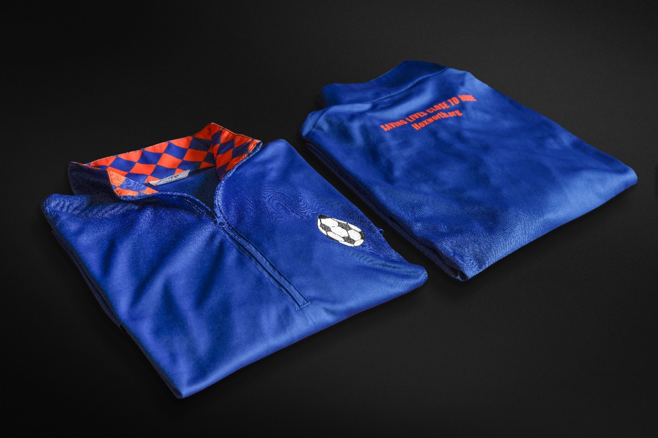 Two FC Cincinnati quarter-zip shirts folded and positioned side by side