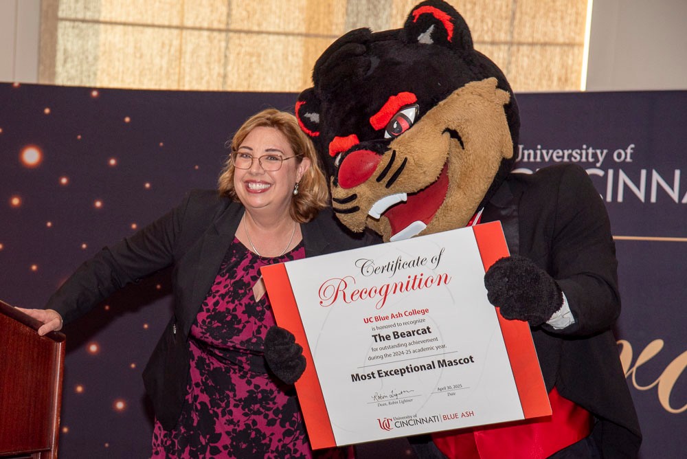 bearcat mascot accepting certificate from dean